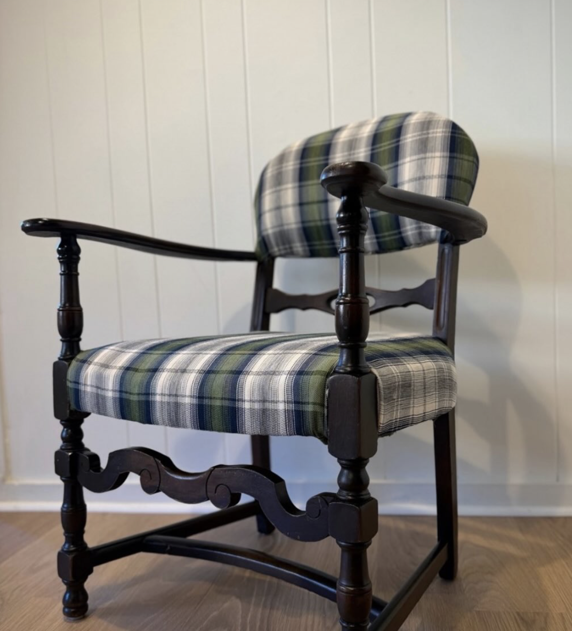 Reupholstered carved armchair in tartan plaid with dark wood frame